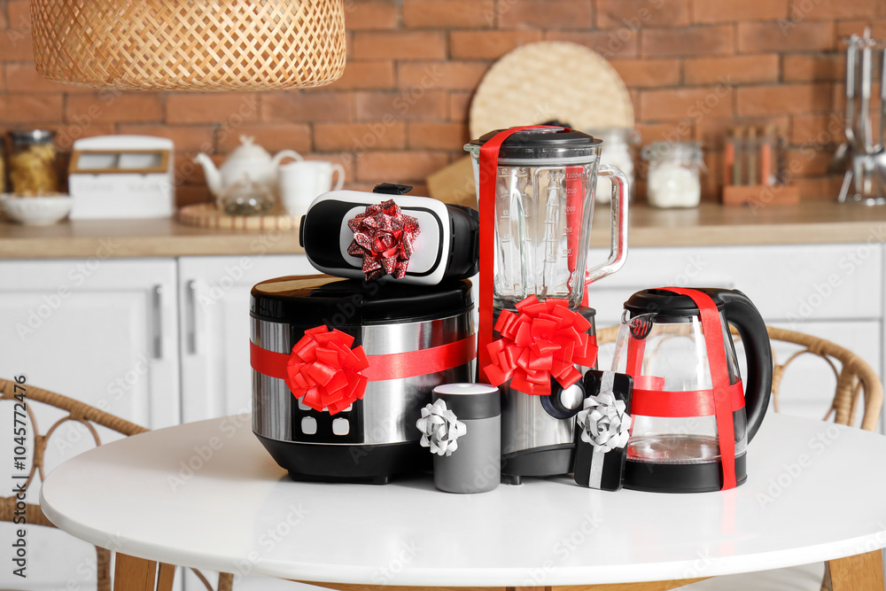 Different household appliances as gift on table in kitchen