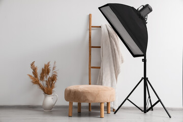 Modern photo studio with pouf and professional lightening equipment