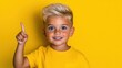 © TimelessClicks - A photostock of a young boy pointing upwards, yellow background, bright mood
