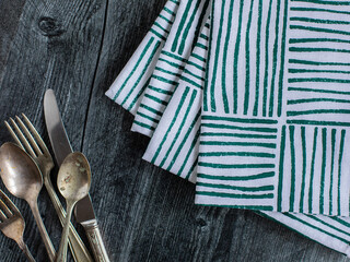 Silverware and napkins on a wooden table.