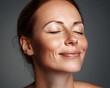 © Prasanth - Smile, eyes closed and skincare of mature woman in studio for glow, results or beauty on gray background. Face, happy and model in natural cosmetics for dermatology, anti aging and aesthetic at spa