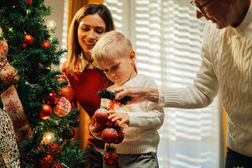 Wall Mural - Happy family decorating christmas tree at home