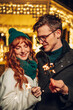 © Zamrznuti tonovi - A happy couple hugging on a street with sparklers in hands on new year