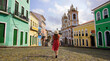 © zigres - Tourism in Salvador de Bahia. Back view of traveler girl descends famous Pelourinho historic center of Salvador de Bahia, UNESCO World Heritage, Brazil.