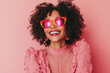 © kristina - Woman in pink sunglasses smiling brightly at the beach, the sun casting a golden glow on her face.