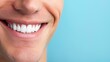 © ChimE - Bright smile of a man with white teeth on a soft blue backdrop, radiating happiness and positivity in a closeup shot.