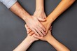 © JK_kyoto - Diverse hands stacked together, symbolizing teamwork and unity on a dark background.