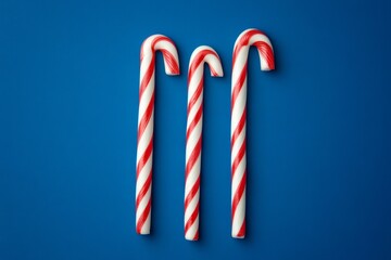 Poster - Three festive candy canes on a blue background.