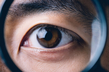 Beautiful detailed macro photography of the eye of a man, woman and children through a magnifying glass as a close or careful focus on the health and optics of vision
