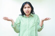 © M Alfan Setyawan - clueless asian woman with dark hair looking at camera with confusion expression raising two palms sideways, showing and presenting gesture, choose product, wearing green shirt isolated on white