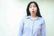© M Alfan Setyawan - shocked asian young business woman looking aside with wowo expression wearing formal shirt standing over isolated white background