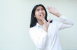 © M Alfan Setyawan - portrait of terrified asian business woman raising palms and looking up with scared face expression wearing white shirt formal suit standing over isolated background