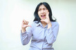 © M Alfan Setyawan - dissatisfied asian young business woman screaming with open mouth protest giving thumbs down looking away feeling upset unhappy wearing formal purple shirt standing over isolated white background