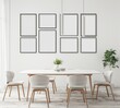 © PERFECTisME - 「ミニマルなダイニングルームインテリア。テーブルと椅子の上の白い壁に空白の額縁。アート作品や写真の展示に最適」