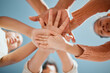 © K Abrahams/peopleimages.com - Kids, hands together or unity below with blue sky for community, care or trust in support. Low angle, closeup or people piling in solidarity or union for motivation, youth or friendship in nature
