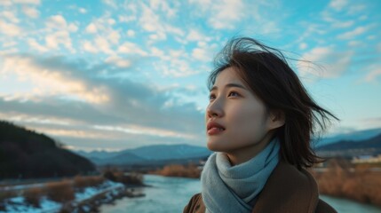 Wall Mural - Young Woman Enjoying Scenic River View at Sunset with Blue Sky