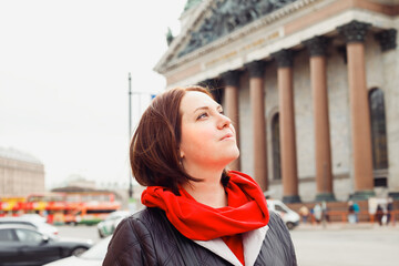 young caucasian woman looking up dreamily outside, portrait of city dweller