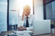 © peopleimages.com - Business, mature man and phone call at office for communication and contact as accountant. Male person, laptop and ceo with conversation, discussion and connection for investment consultation