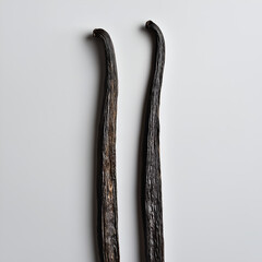 Two vanilla beans on a white background