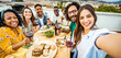© Davide Angelini - Happy friends having fun at rooftop dinner party - Group of young people taking selfie photo at outdoors dining table - Life style concept with guys and girls eating food and drinking wine together