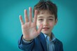 © Needless - A boy wearing blue suit waiving hand saying hello happy and smiling, standing on blue background