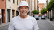© QuoDesign - Senior man wearing white t-shirt and white bucket hat standing on the street