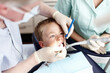 © peopleimages.com - Dentist, staff and boy with mirror for consultation, teeth whitening and oral inspection of dental hygiene. Orthodontics, man and child with cleaning procedure, cavity assessment and braces treatment