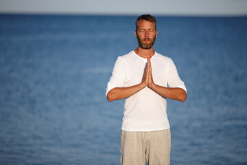 Mature, man and meditation with yoga at ocean for mindfulness healing, spiritual peace and performance. Male person, zen and water with chakra zen for mental health, mindset balance and nature aura