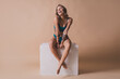 © deagreez - Full body photo of attractive young girl sit white cube laughing wear cyan fashion lingerie isolated beige background no filter