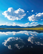 © DigitalArt - Tranquil lake with reflections of clouds and mountains under a clear blue sky, creating a serene and peaceful landscape.