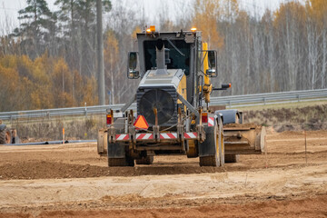 Large ground leveling machine or grader for road or street highway making.