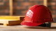© Sanchat - Red hard hat on a wooden surface, close-up, white isolate background