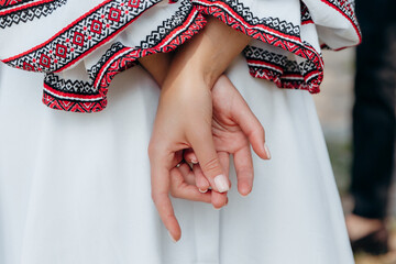 Gentle hands of a girl in a stylish modern fashionable Ukrainian style dress with embroidery. A new style of Ukrainian traditional clothing