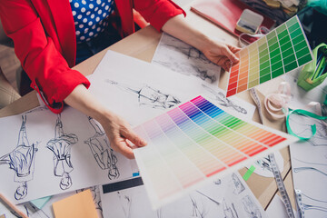 Cropped photo of aged clothing designer lady hands hold color palette loft interior office studio indoors