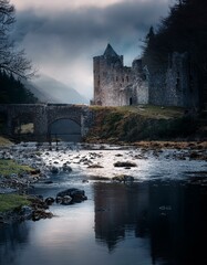 Castillo medieval en ruinas en un dia nublado, junto a un rio y  un puente