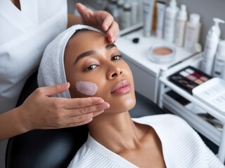 A serene facial treatment session with a therapist applying a mask on a woman's face