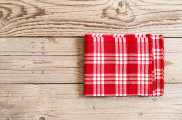 Red kitchen towel top view on wooden background empty space. Food advertisement design. Vintage meal backdrop.