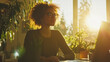 © VERTEX SPACE - A woman with curly hair sits at desk, gazing thoughtfully out window as sunlight streams in, illuminating plants around her. warm glow creates serene atmosphere