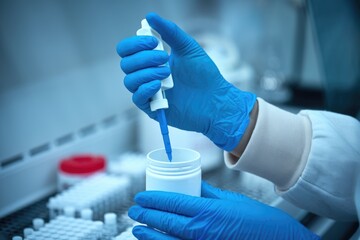 Aufkleber - A scientist in a lab uses a pipette to dispense liquid into a container.
