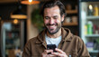 © John_Doo78 - Happy man reading a message on the phone and smiling