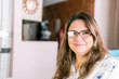 © Centric  - Plus-size Latina woman with glasses smiling confidently while working remotely in her home office