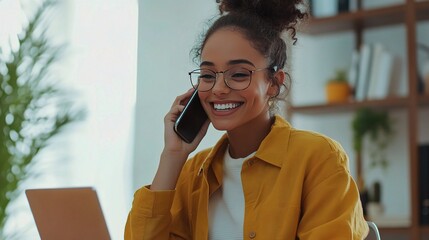 Wall Mural - Joyful Woman Talking on Phone with Laptop Nearby