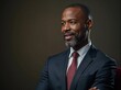 © Alex - A confident African American man in a suit poses thoughtfully against a dark background during an indoor portrait session