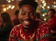 © Alex - Joyful African American man wearing a festive sweater smiles warmly in a cozy holiday gathering with twinkling lights
