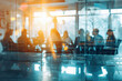 © Bougie Banana - Blurred team meeting behind glass partitions in modern corporate office during sunset