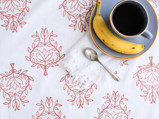 breakfast table setting with coffee and a banana