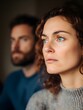 © Alexey - Tense couple portrait with woman in focus and man behind. Relationship crisis concept. Domestic conflict photography