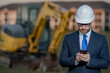 © Volodymyr - Construction builder investor. Man investor in front of construction site. Successful handsome man standing at modern home building construction. Portrait of midlle aged investor in suit and helmet.