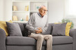 © Ljupco Smokovski - Elderly man with abdominal pain sitting on sofa