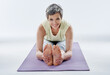 © peopleimages.com - Stretching, yoga and mature woman with smile, fitness and wellness with routine, health or warm up. Gym, flexible and activity for pilates, workout and exercise for person, morning or portrait in USA